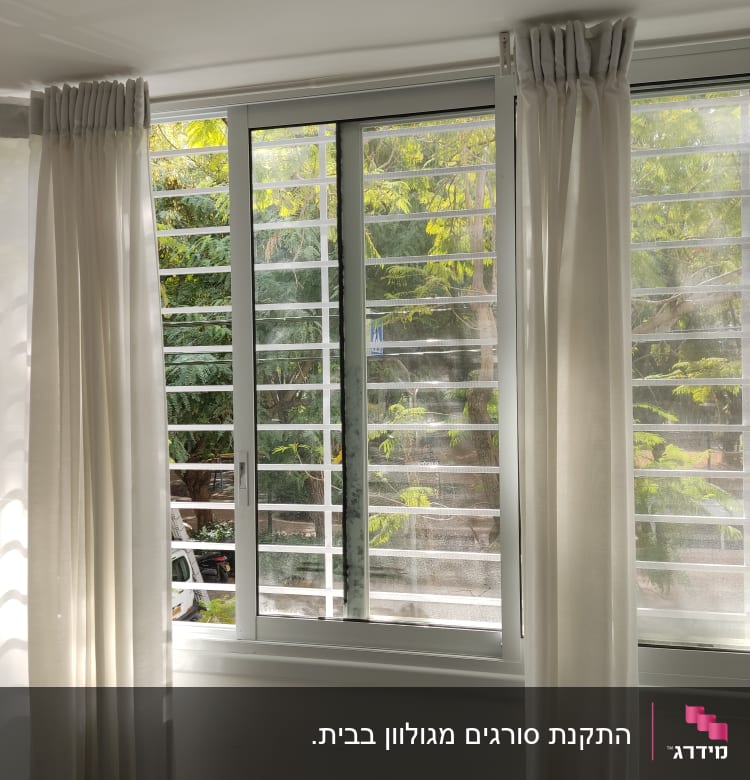 חלון עם מסגרת לבנה ווילונות לבנים